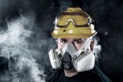 Homme portant un masque à gaz entouré de vapeurs