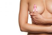 Femme nue portant un ruban rose, symbole du cancer du sein, sur sa poitrine