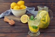 Pichet et verre de jus de citron et coupelle de citrons jaunes