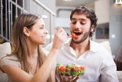 Jeune couple qui mange une salade