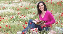 Valérie Cupillard dans l'herbe avec ses livres de recettes