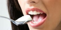 femme portant une cuillère de yaourt à sa bouche