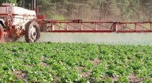 Tracteur pulvérisant son champ de pesticides
