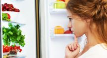 Jeune femme analysant le contenu dans son frigo