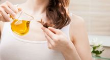 une femme mettant de l'huile de moringa sur la pointe de ses cheveux
