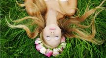 une femme aux longs cheveux allongée dans l'herbe