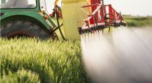 épandage de pesticides dans un champs avec un tracteur
