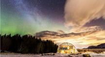 une maison en dôme géodésique en Arctique sous les aurores boréales
