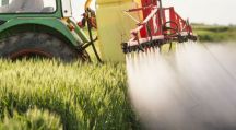 un tracteur déverse des pesticides sur une zone agricole