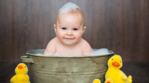 Un bébé dans son bain avec canard en plastique