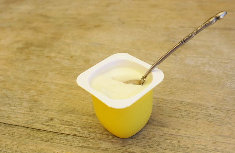 Petit pot de yaourt jaune et petite cuillière