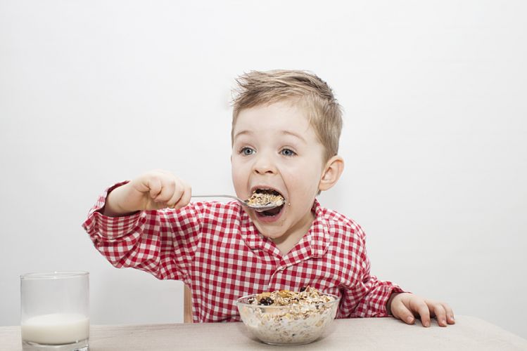 Petit garçon mangeant un bol céréales 