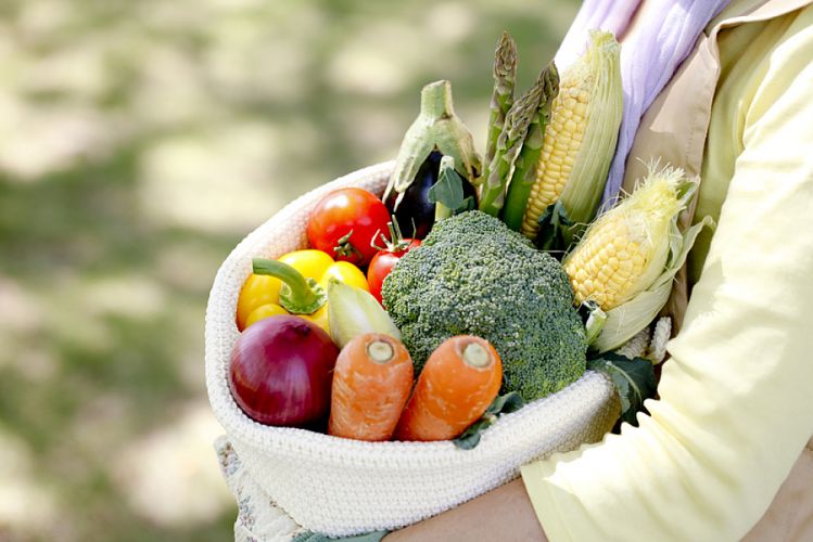 Femme portant un sac en tissu rempli de légumes