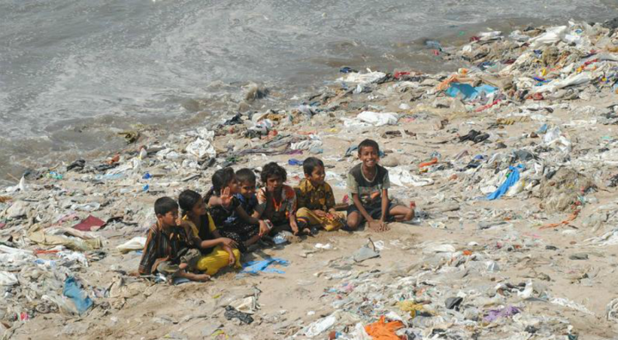 Enfants sur une plage jonchée de déchets