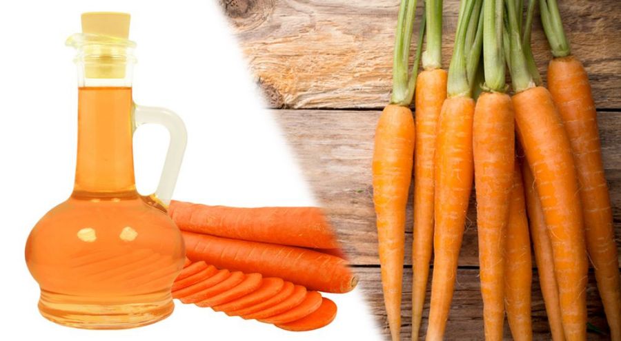 Huile de carotte et carottes posés sur table en bois