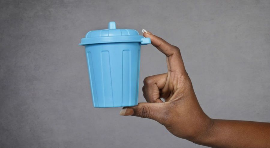 Main présentant une petite poubelle en plastique