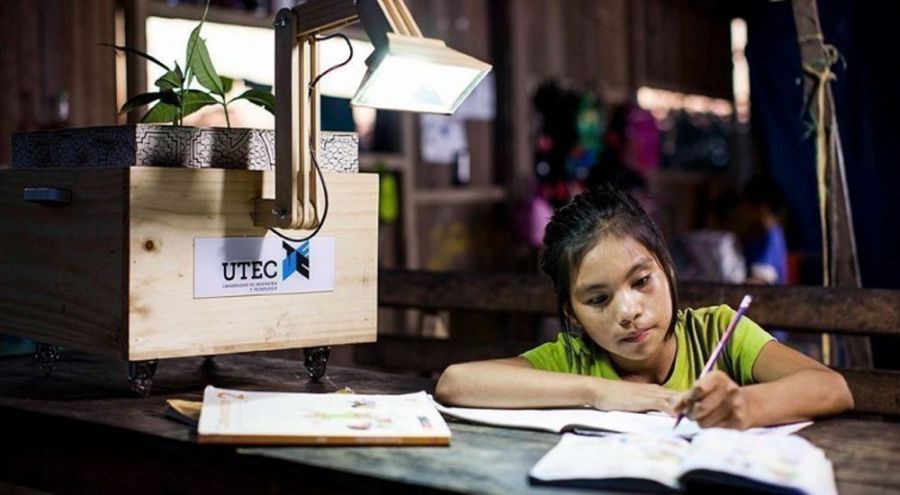 Jeune fille écrit sur un cahier et est éclairé par une lampe à sève