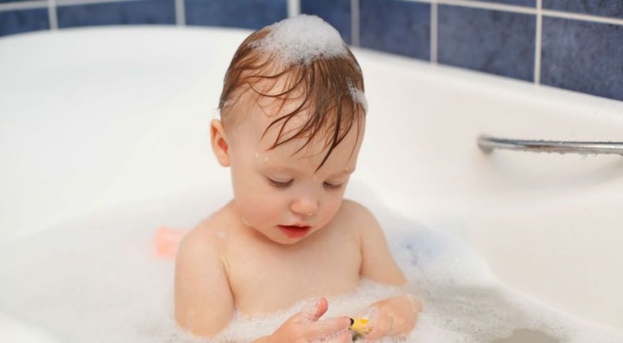un bébé jouant avec de la mousse dans le bain