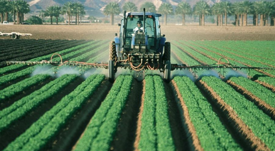 Un tracteur verse des pesticides dans un champ