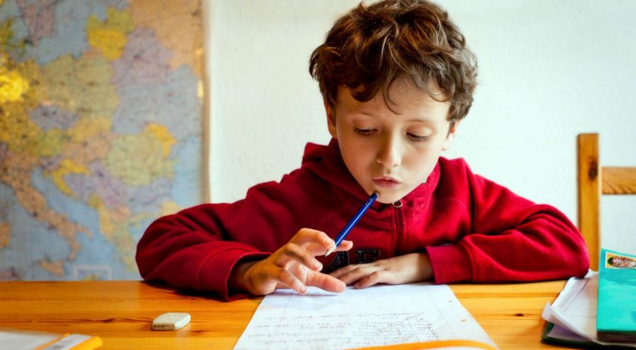 un enfant fait ses devoirs scolaires