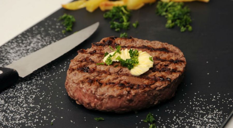 un steak haché sur une assiette en ardoise
