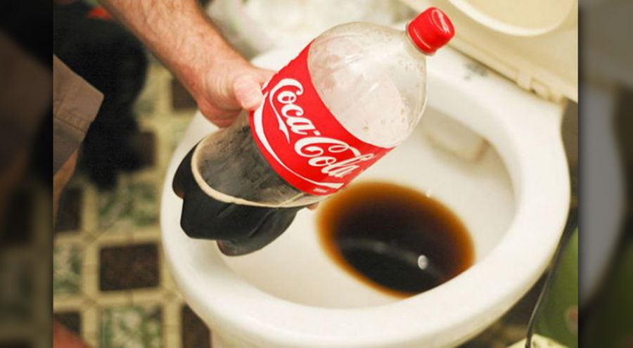 Un homme verse du Coca-Cola dans la cuvette des toilettes