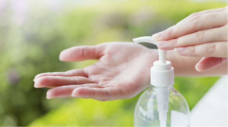 une femme se nettooie les mains avec du gel antibactérien